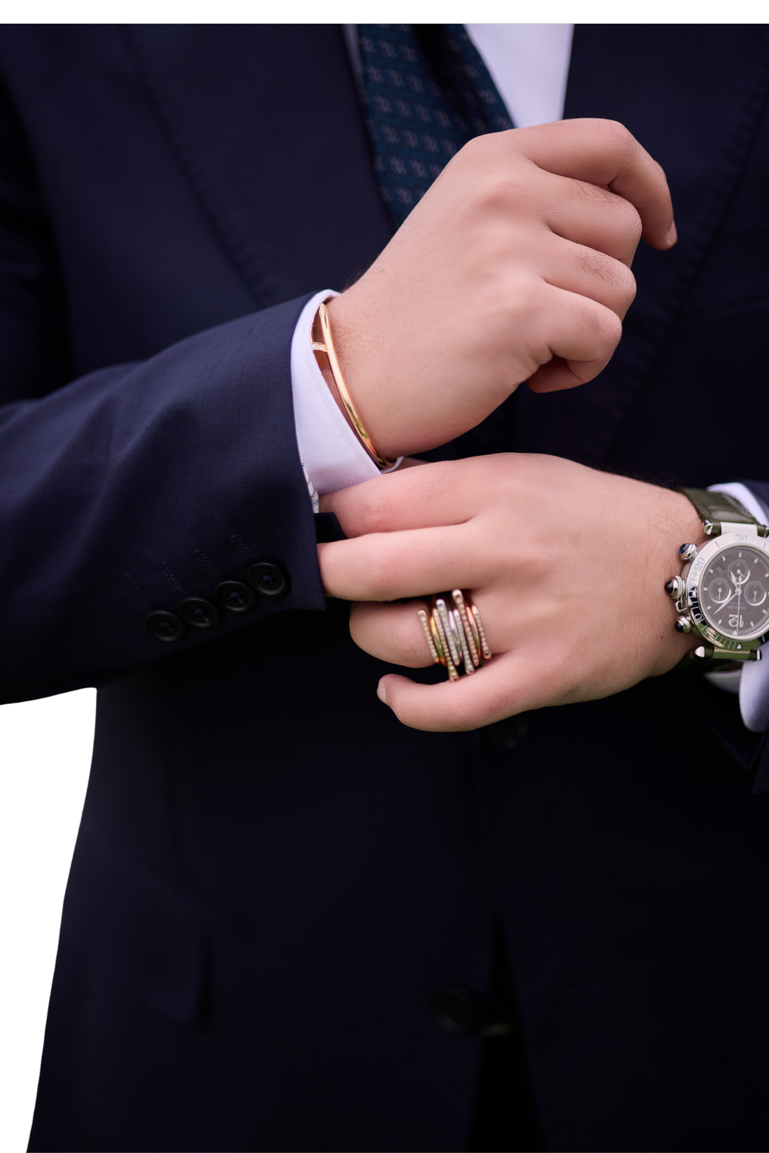 Close-up of Ahmed adjusting his suit cuff